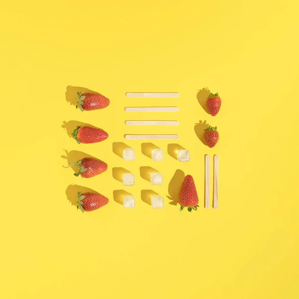 Neatly Arranged Strawberries Ice Cubes Popsicle Sticks Sunny Yellow Background — стоковое фото