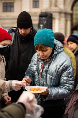 Lviv, Ukrayna, 2022: Lviv 'deki tren istasyonu yakınlarında yiyecekleri olan mülteciler