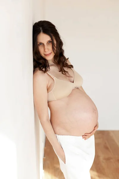 Genç Güzel Hamile Bir Kız Parlak Bir Odada Ellerini Karnının Stok Resim