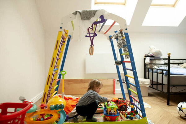 Little girl playing with toys in her room