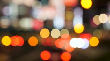 Shinjuku 'daki yoğun Tokyo yolunun, aydınlık neon ekranlı bulanık gece görüntüsü..