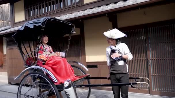 Mujeres japonesas en vestido tradicional sentadas en rickshaw, Kyoto, Japón — Vídeo de stock