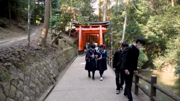 Japanska studenter promenader i Fushimi Enare full av torii grindar Kyoto, Japan. — Stockvideo