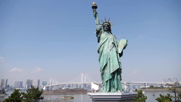 Statuia Libertății din Odaiba și zgârie-nori din Tokyo cu podul Curcubeu în fundal, Japonia. — Videoclip de stoc