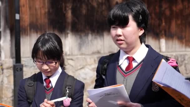A japán diákok megállítják a turistákat, megpróbálnak velük beszélni és angolul tanulni. — Stock videók
