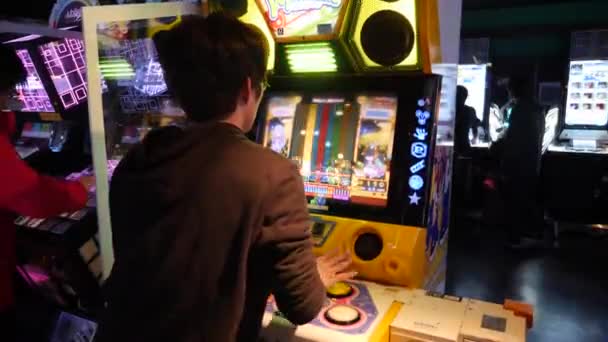 Joven chico japonés pasar tiempo en Sega jugando videojuego en Akihabara. Arcade. — Vídeos de Stock