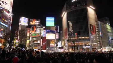 Meşgul ve ünlü yayalar Tokyo 'dan Shibuya Geçidi' ne yürüyorlar..