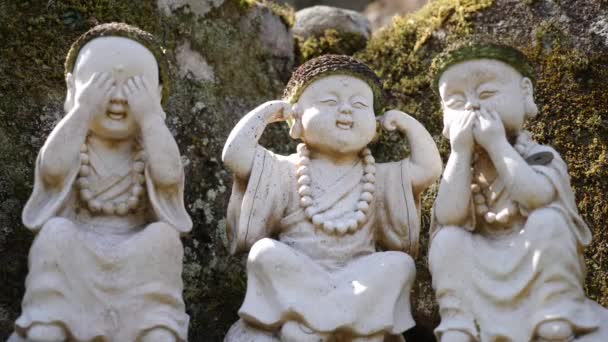 Stenen figuren van Boeddha handelend als drie wijze apen Mizaru, Kikazaru, Iwazaru — Stockvideo