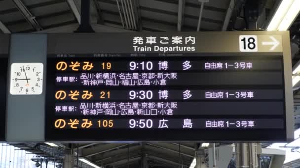 Duży znak z odjeżdżających pociągów na głównej stacji kolejowej Tokio. — Wideo stockowe