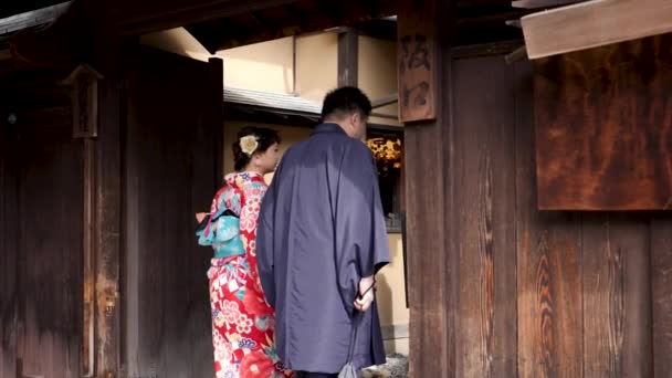 在日本京都，一对日本夫妇进入了传统的日本商人住宅. — 图库视频影像