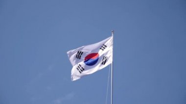 Rüzgarda dalgalanan Güney Kore bayrağı, güneşli mavi gökyüzü arka planı