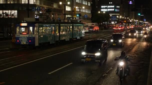 Busy traffic in the heart of Hiroshima. Tram, bus and cars moving at night. — ストック動画