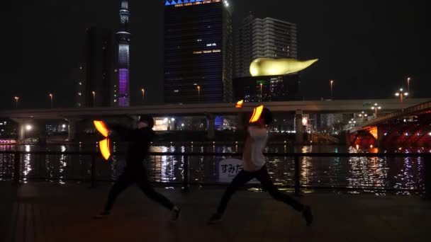 Show de fogo de dois jovens rapazes japoneses em frente ao edifício japonês mais alto — Vídeo de Stock