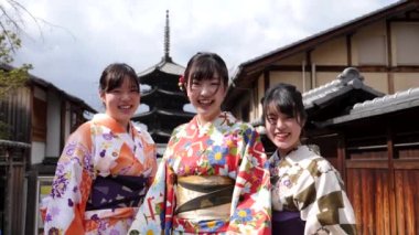 Smiling young beautiful japanese girls wearing a traditional japanese kimono.