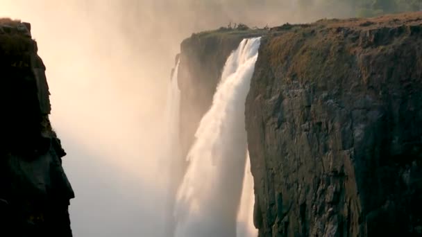 伟大的维多利亚瀑布在日落时分落在与赞比亚交界的津巴布韦境内 世界七大自然奇观 赞比西河上的Mosi Tunya — 图库视频影像
