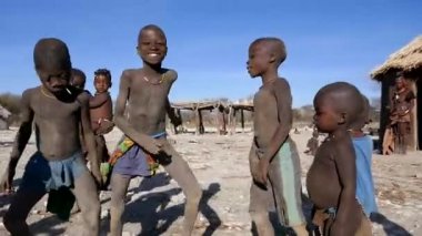 Opuwo, Namibya - 23 Mayıs 22: Genç Himba çocukları Namibya, Afrika 'daki geleneksel köyde dans ediyorlar. Afrikalı Himba çocukları dans ediyor. Afrika 'daki etnik kabile grupları. Yüksek kaliteli FullHD görüntüler.