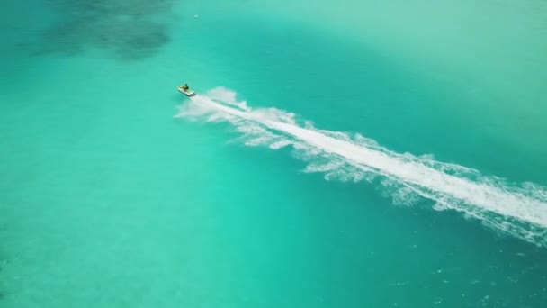 透明なターコイズブルーの水の上でジェットスキーレースの空中ビュー ジェットスキーでモルディブの夏休みをお楽しみください モルディブでの活動 高品質4K映像 — ストック動画