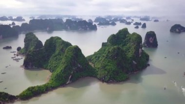 Vietnam 'daki Mystical Ha Long Körfezi' nin hava görüntüleri. Dik kayalıkların üzerinde uçmak. Aşağı inen ejderha. Vietnam 'daki en iyi seyahat turizmi. Halong Körfezi 'nde yüksek kaliteli 4k görüntü..
