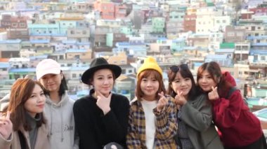 Busan, South Korea - July 23, 22: Cute Korean young girls posing for photo in Gamcheon Culture Village. Nickname is Machu Picchu of Busan. High quality 4k footage. 