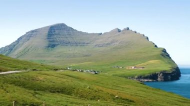Villingadalsfjall green and rocky Summit in Faroe Islands. The top of the mountain in Faroe Islands. High quality 4k footage. Vidoy Island. Small village in Faroe Islands.