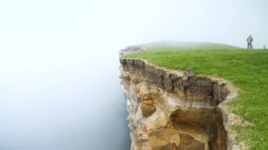 4K Beautiful view of the foggy Traelanipan, Slave mountain in Vagar, Faroe Islands. Perpendicular rock wall. Amazing nature in Faroe Islands. Vagar Island, Faroe Islands. Cloudy day in summer.