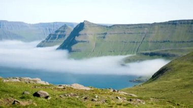 4K Beautiful view of the foggy Funningur valley. Amazing nature in Faroe Islands. Eysturoy Island. Faroe Islands. Gonguturur or Hvithamar. Sunny day in summer.