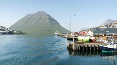 Ferry arriving at the port in Klaksvik. Kunoy Island in the background. High quality 4k footage. Bordoy Island. Klaksvik is second biggest city in Faroe Islands. Harbour full of boats in Faroe.