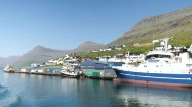 Ferry arriving at the port in Klaksvik. Kunoy Island in the background. High quality 4k footage. Bordoy Island. Klaksvik is second biggest city in Faroe Islands. Harbour full of boats in Faroe.