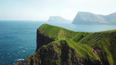 Aerial view of Kalsoy island, Faroe Islands. Amazing Faroese nature, green hills and beautiful rocky cliffs and mountains. Kallur lighthouse. Sunny day in summer. Movie Island in Faroe. 4k footage