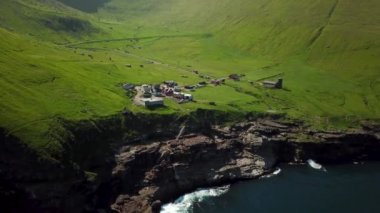Aerial view of Kalsoy island, Faroe Islands. Amazing Faroese nature, green hills and beautiful rocky cliffs and mountains. Kallur lighthouse. Sunny day in summer. Trollanes village. 4k footage