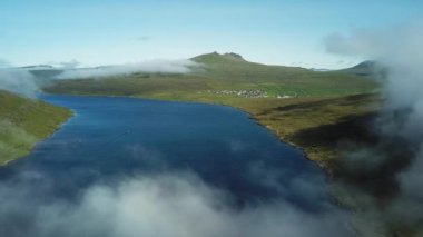 Aerial view of Sorvagsvatn lake or Leitisvatn, Biggest lake in Faroe Islands. Flying through the clouds. Amazing mist and foggy Faroese nature. High quality 4k footage.