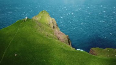 Aerial view of Kalsoy island, Faroe Islands. Amazing Faroese nature, green hills and beautiful rocky cliffs and mountains. Kallur lighthouse. Sunny day in summer. Movie Island in Faroe. 4k footage