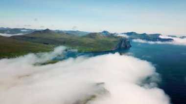 Aerial view of a Slave Cliff or Traelanipa hidden in the mist, Faroe Islands. Flying above the clouds. Amazing mist and foggy Faroese nature. High quality 4k footage.