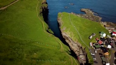 Aerial view of a canyon in Gjogv village in Faroe Islands. Sunny day in summer. Amazing nature in Faroe Islands. Eysturoy Island. Faroese canyon. Natural harbour in Gjogv.