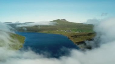 Aerial view of Sorvagsvatn lake or Leitisvatn, Biggest lake in Faroe Islands. Flying through the clouds. Amazing mist and foggy Faroese nature. High quality 4k footage.
