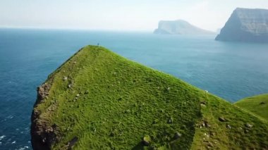 Aerial view of Kalsoy island, Faroe Islands. Amazing Faroese nature, green hills and beautiful rocky cliffs and mountains. Kallur lighthouse. Sunny day in summer. Movie Island in Faroe. 4k footage