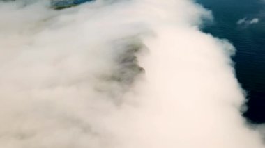 Aerial view of a Slave Cliff or Traelanipa hidden in the mist, Faroe Islands. Flying above the clouds. Amazing mist and foggy Faroese nature. High quality 4k footage.
