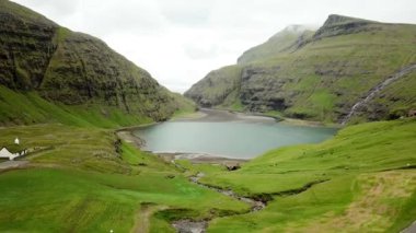 Aerial view of a lagoon in Saksun village, Faroe Islands. Lagoon in beautiful green nature in Saksun. Mist faroese nature. High quality 4k footage.