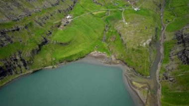 Aerial view of a lagoon in Saksun village, Faroe Islands. Lagoon in beautiful green nature in Saksun. Mist faroese nature. High quality 4k footage.