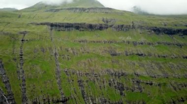 Green and rocky Summit in Faroe Islands. The top of the mountain in Faroe Islands. High quality 4k footage. Eysturoy Island.