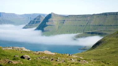 4K Beautiful view of the foggy Funningur valley. Amazing nature in Faroe Islands. Eysturoy Island, Faroe Islands. Gonguturur or Hvithamar. Sunny day in summer.