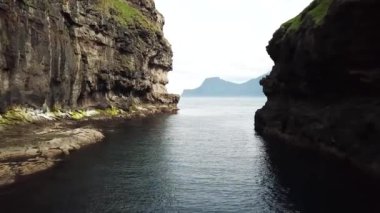 Aerial view of a canyon in Gjogv village in Faroe Islands. Sunny day in summer. Amazing nature in Faroe Islands. Eysturoy Island. Faroese canyon. Natural harbour in Gjogv.