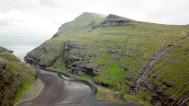 Aerial view of a lagoon in Saksun village, Faroe Islands. Lagoon in beautiful green nature in Saksun. Mist faroese nature. High quality 4k footage.