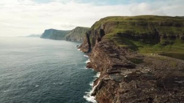Aerial view of huge cliffs near Slave cliff or Traelanipan and Sorvagsvatn lake or Leitisvatn in Faroe Islands. Amazing nature. Huge cliffs. Lake above the ocean. Bosdalafossur waterfall. 4k footage.