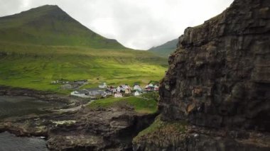 Aerial view of a canyon in Gjogv village in Faroe Islands. Sunny day in summer. Amazing nature. Eysturoy. Faroese canyon. Natural harbour in Gjogv. Tyril and Slaettaratindur in the background.