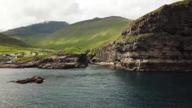 Aerial view of a canyon in Gjogv village in Faroe Islands. Sunny day in summer. Amazing nature in Faroe Islands. Eysturoy. Faroese canyon. Natural harbour in Gjogv. Slaettaratindur in the background.