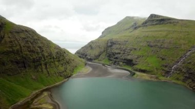 Aerial view of a lagoon in Saksun village, Faroe Islands. Lagoon in beautiful green nature in Saksun. Mist faroese nature. High quality 4k footage.