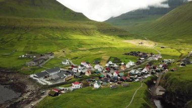 Aerial view of a canyon in Gjogv village in Faroe Islands. Sunny day in summer. Amazing nature. Eysturoy. Faroese canyon. Natural harbour in Gjogv. Tyril and Slaettaratindur in the background.