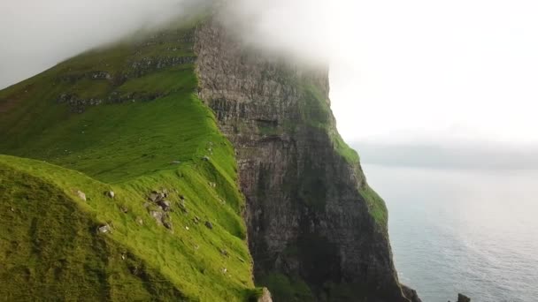 一个男人站在悬崖上从空中俯瞰着卡鲁塞岛 法罗群岛 神奇的法罗群岛自然 美丽的岩石悬崖和山 Kallur灯塔阳光灿烂的日子 4K镜头 — 图库视频影像