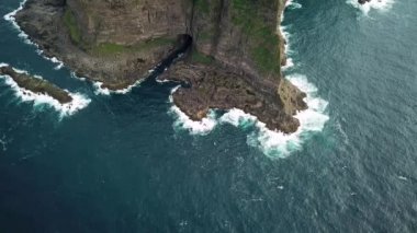 Faroe Adaları 'ndaki Kalsoy adasındaki uçurumların insansız hava aracı görüntüsü. Muhteşem Faroe doğası, yeşil tepeler ve güzel kayalıklar ve dağlar. Kallur deniz feneri. Yazın güneşli bir gün. Kaliteli 4k görüntü.